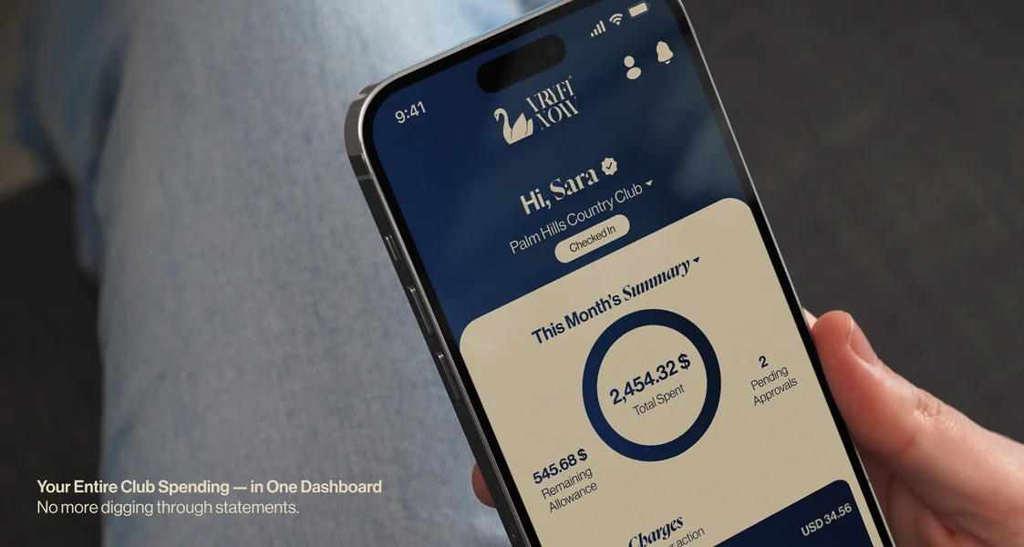 A hand holding a phone showing the Vryfi Now spending dashboard