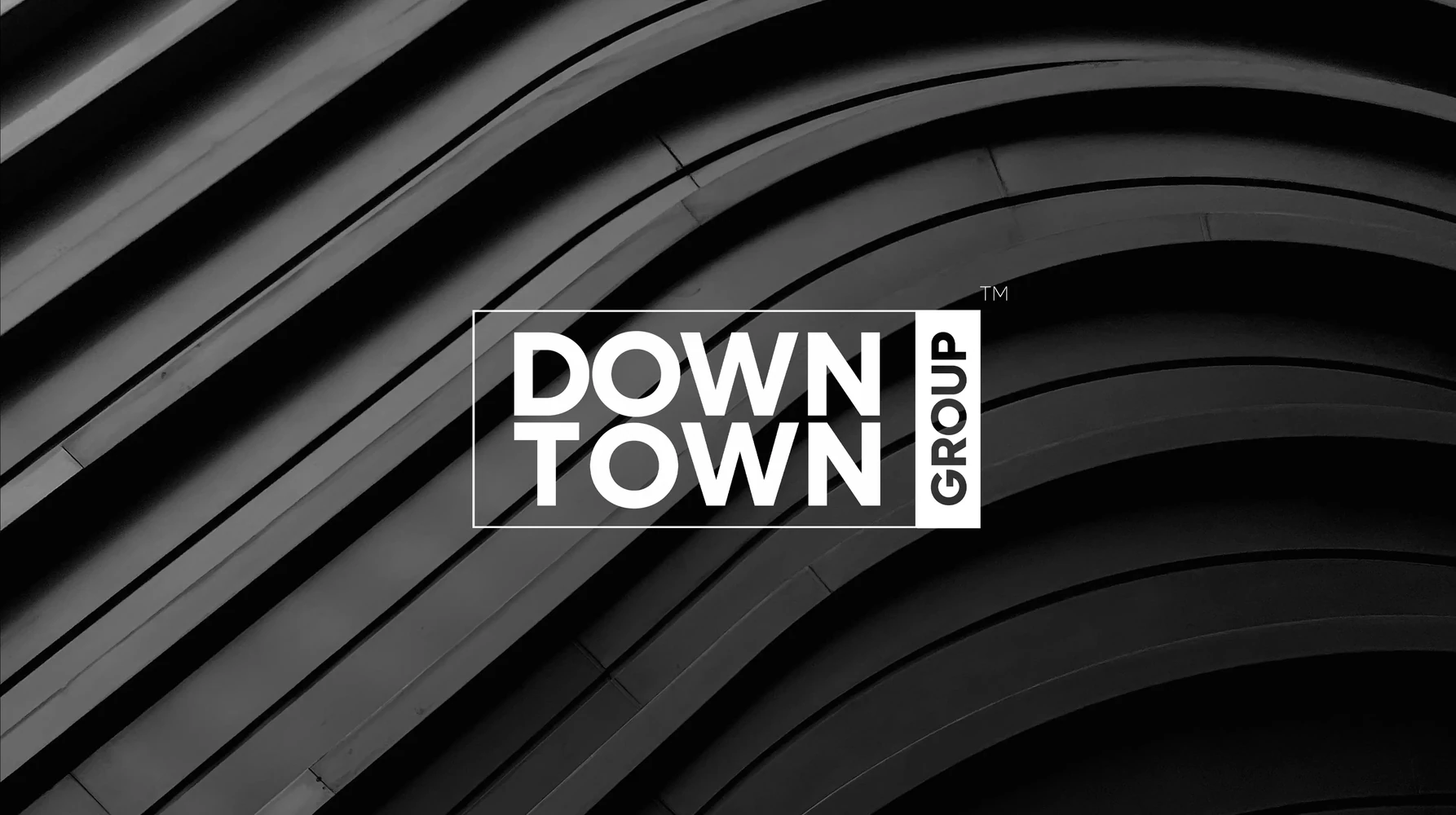 Downtown Group logo on a curved black architectural facade